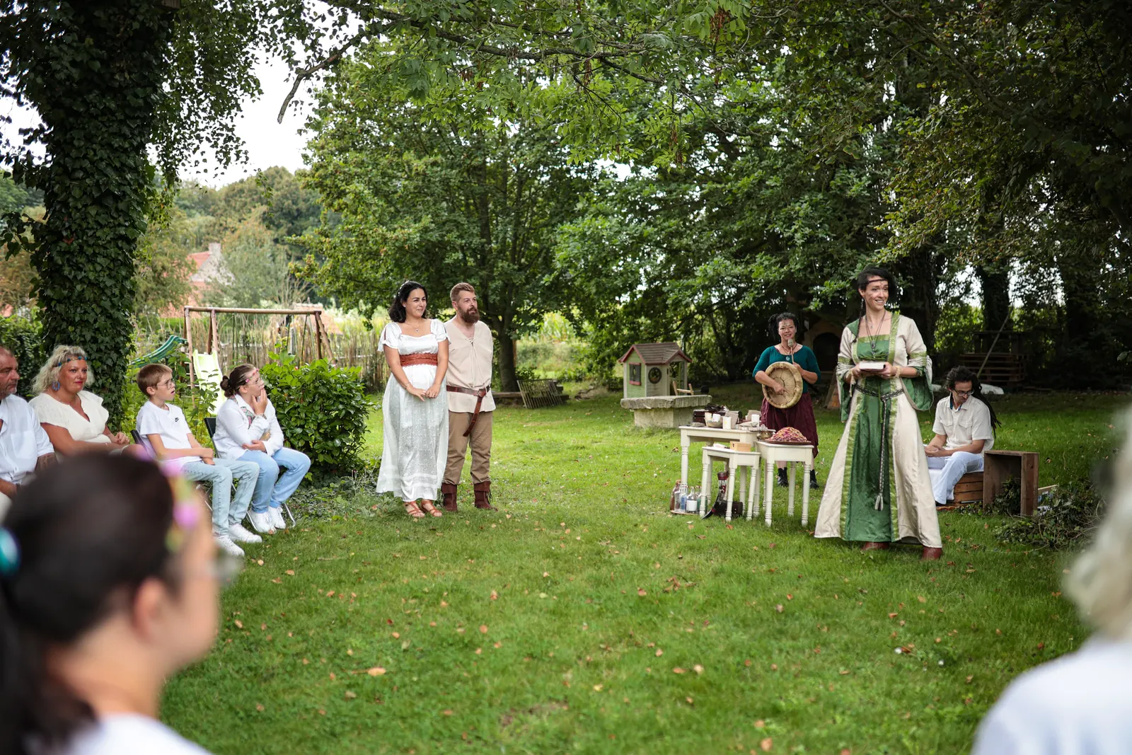 L'officiante accueille les invités assis en cercle dans le jardin
