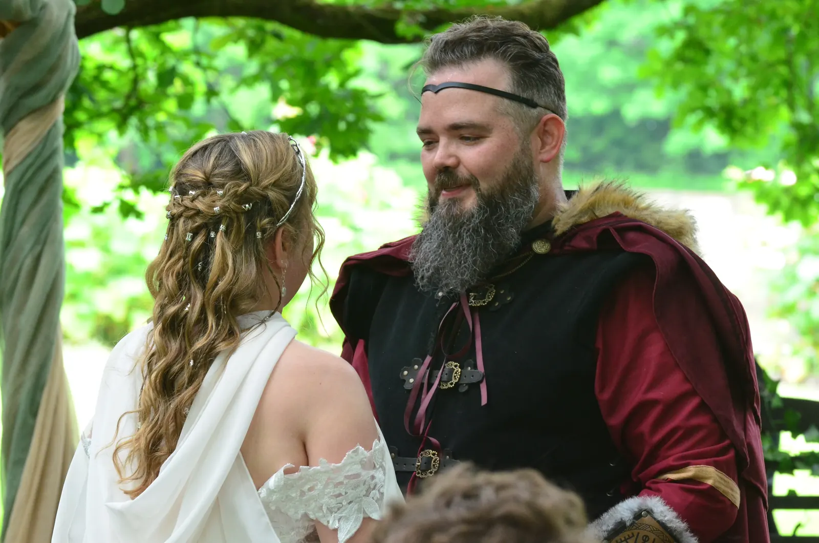 La mariée aux cheveux tressés face au marié en cape de fourrure