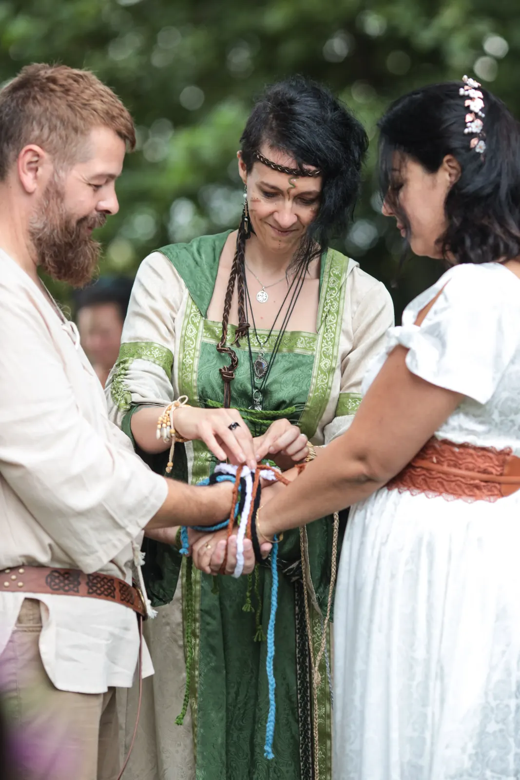Handfasting d'inspiration écossaise : mains des mariés liées de rubans colorés